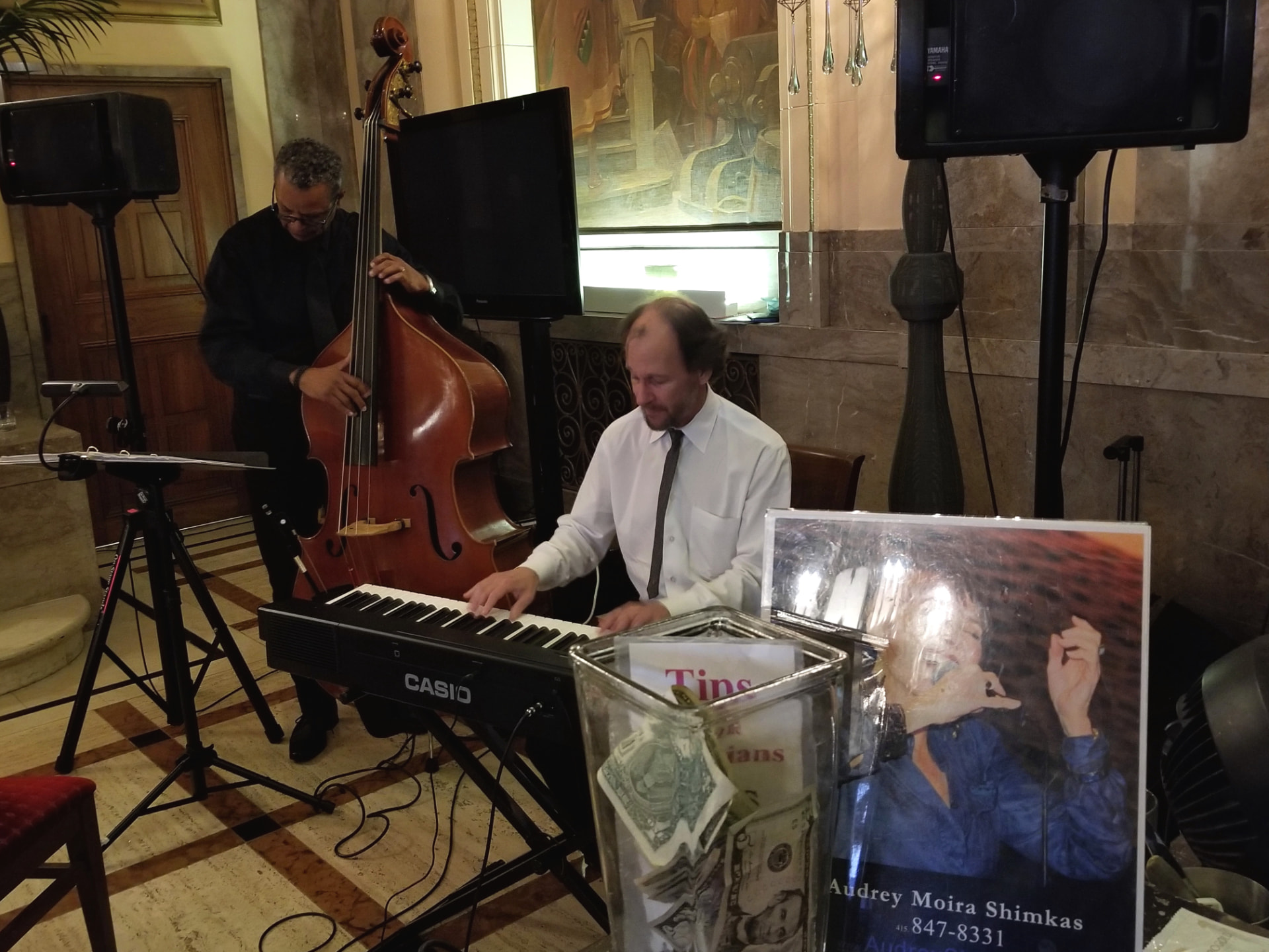 Bassist and pianist performing in a grand hotel lobby