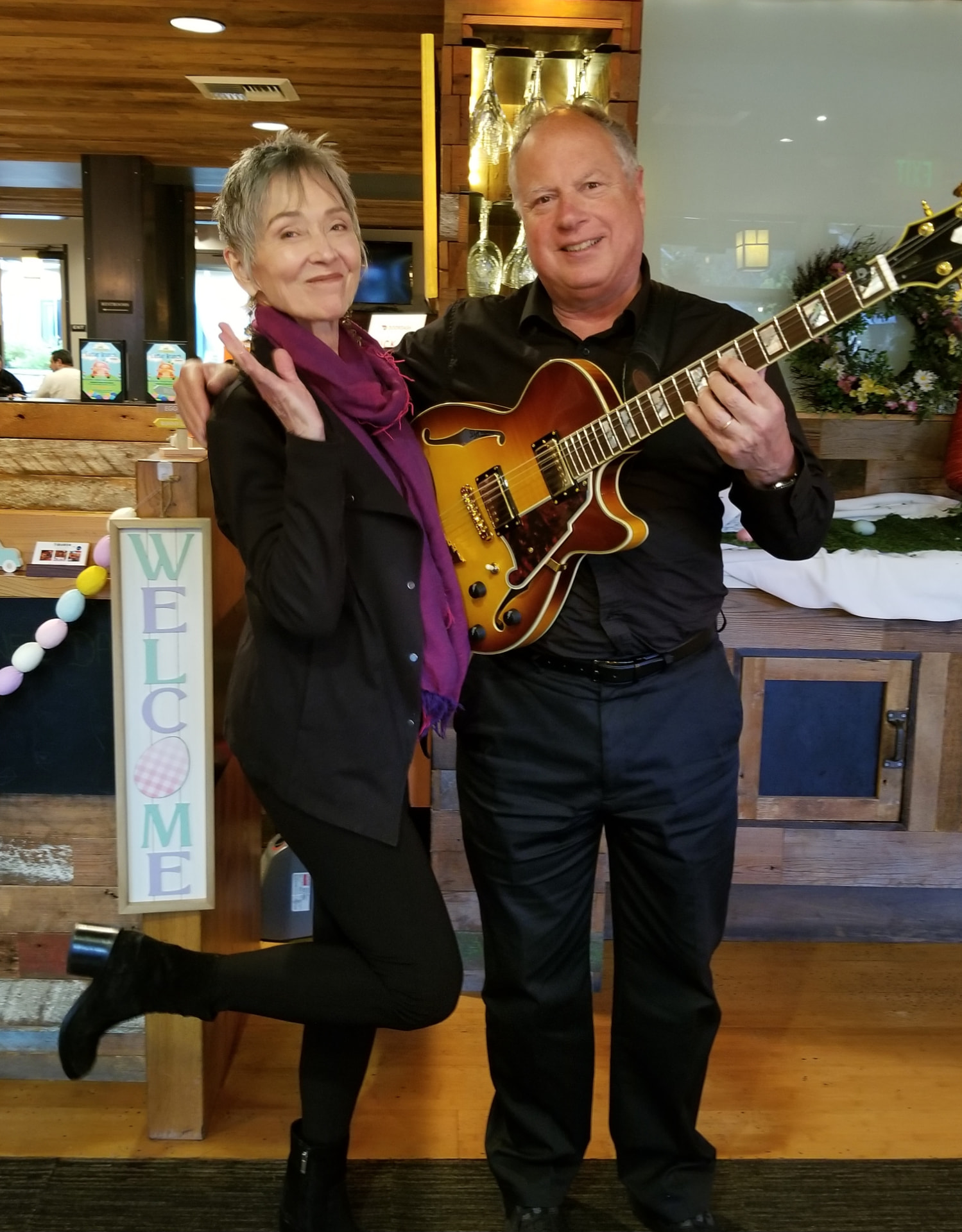 Audrey posing with the guitarist and his archtop guitar