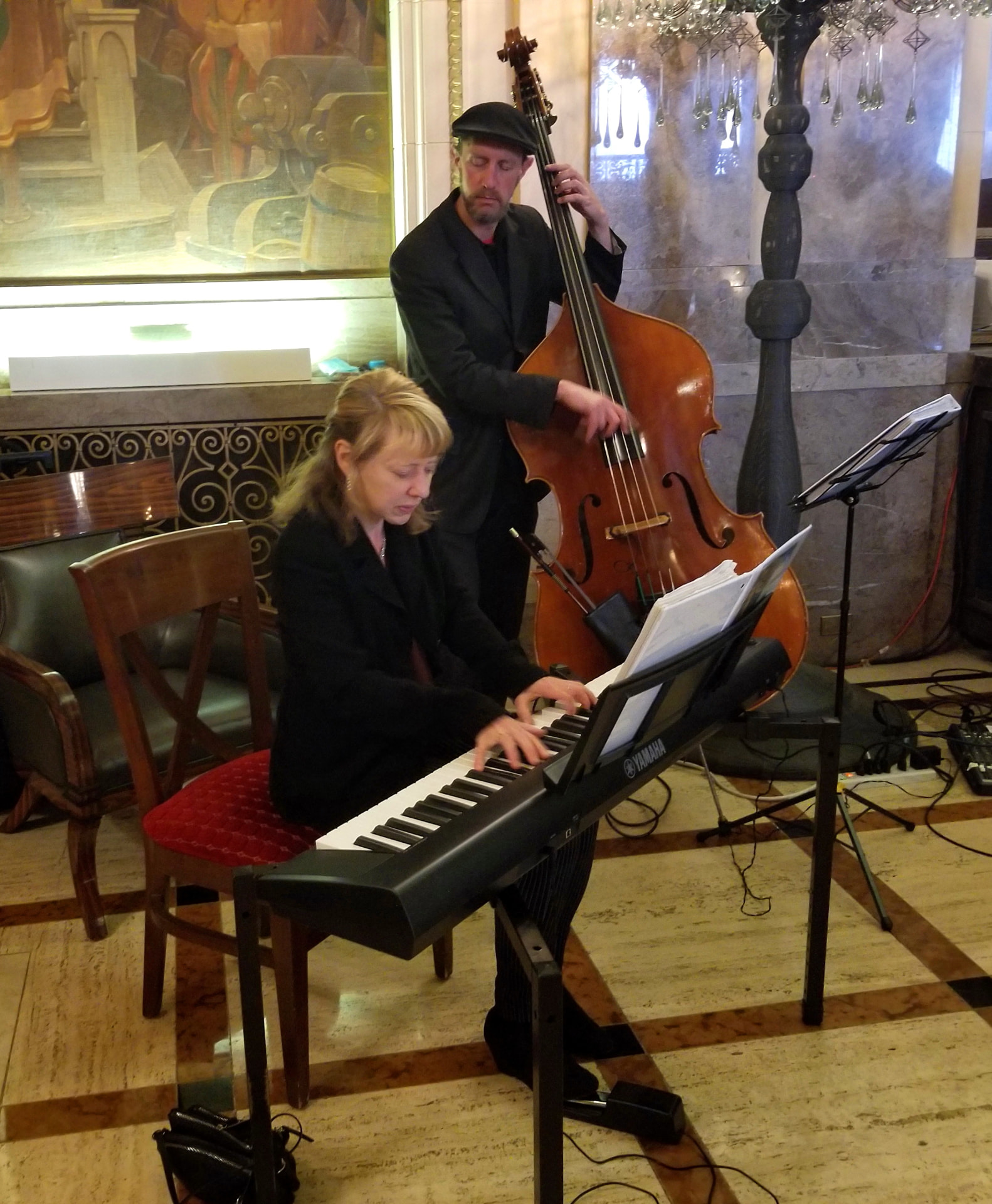 Pianist and upright bassist performing in a marble lobby