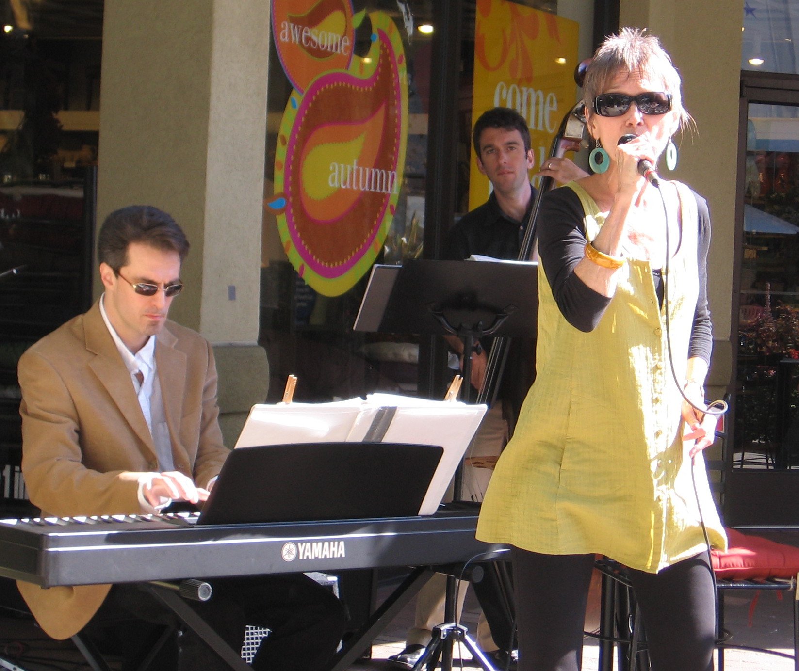 Audrey singing outdoors with pianist and upright bassist