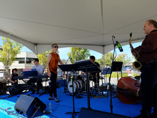 The band setting up on stage under a tent before a festival set