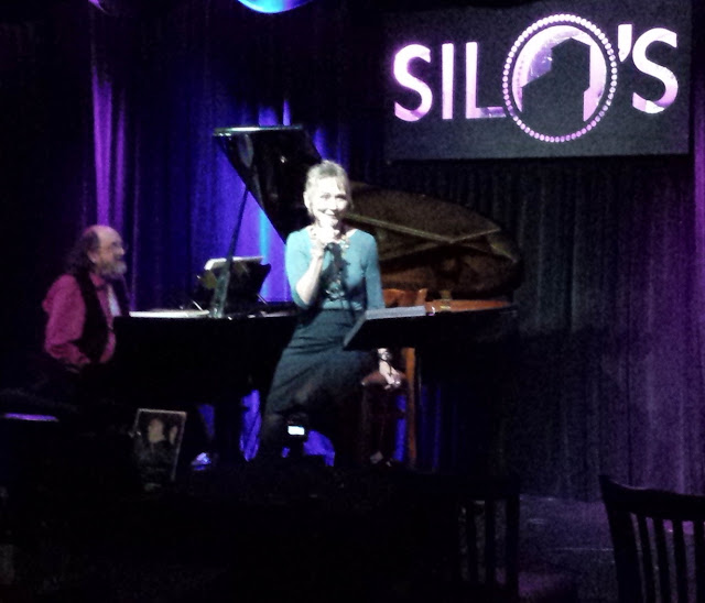 Audrey singing on stage with a pianist at Silo's